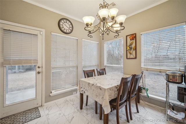 dining space with ornamental molding, a wealth of natural light, and a chandelier