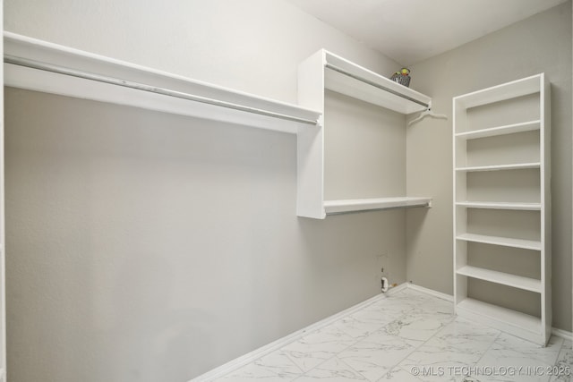 spacious closet with marble finish floor