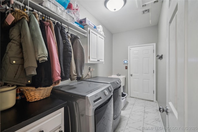 washroom featuring cabinets, sink, and washing machine and clothes dryer