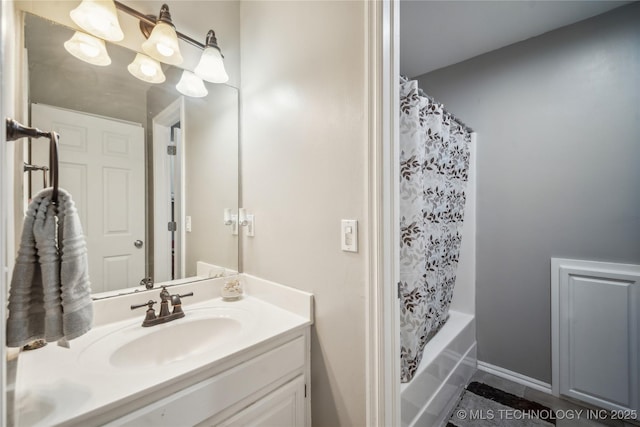 full bath featuring vanity, baseboards, and shower / bath combo with shower curtain