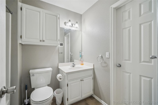 bathroom with vanity, a textured wall, and toilet