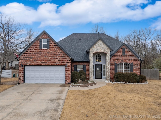 traditional home featuring fence, a shingled roof, brick siding, a front yard, and driveway