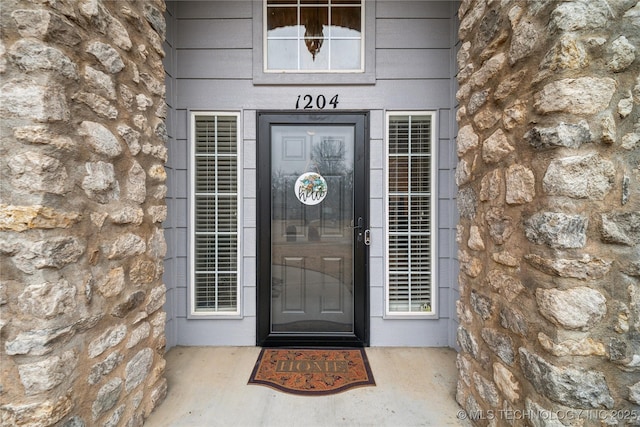 doorway to property featuring stone siding