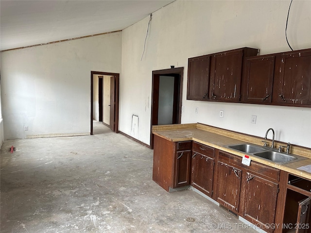 kitchen featuring dark brown cabinetry, sink, and high vaulted ceiling