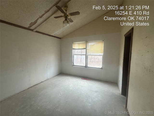 spare room with lofted ceiling, a textured ceiling, and ceiling fan