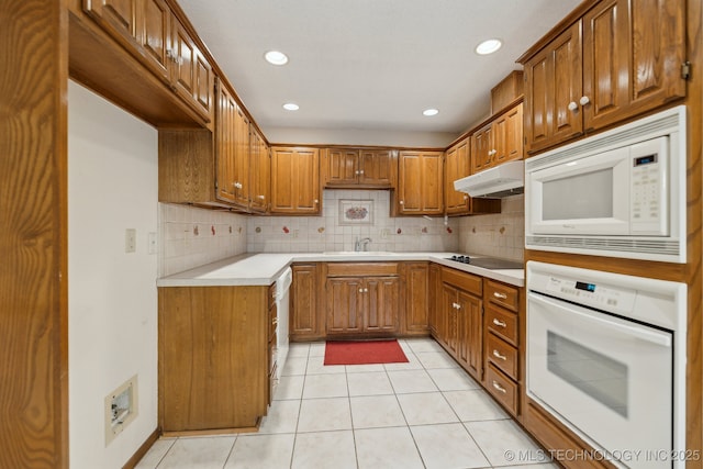 kitchen with tasteful backsplash, white appliances, and light tile patterned flooring