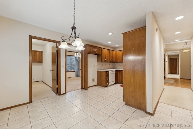 kitchen featuring light tile patterned floors, decorative backsplash, white dishwasher, and decorative light fixtures