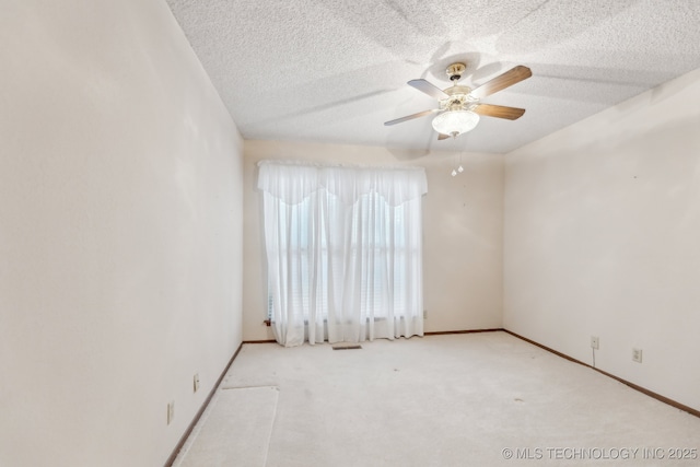 carpeted spare room featuring ceiling fan and a textured ceiling