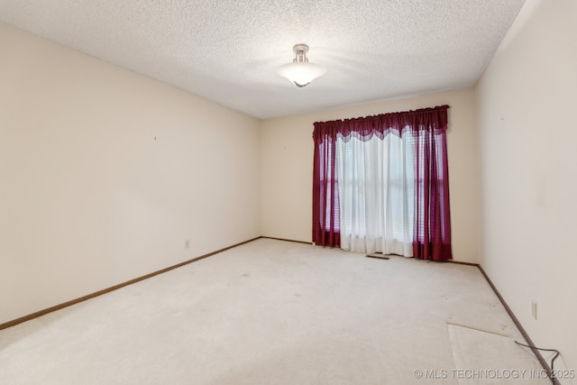 carpeted empty room with a textured ceiling