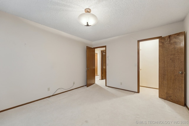 unfurnished bedroom featuring light colored carpet and a textured ceiling