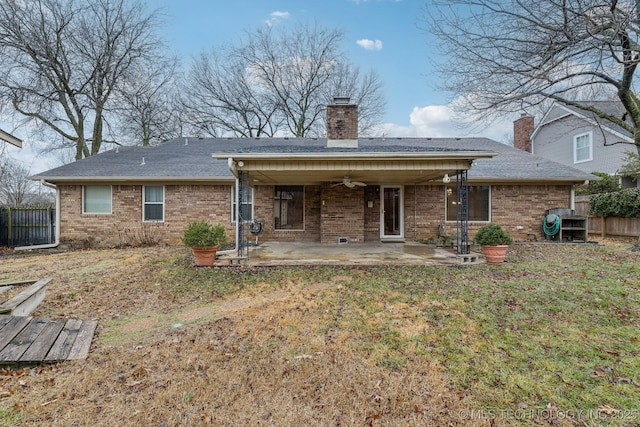 rear view of property with ceiling fan, a patio, and a lawn