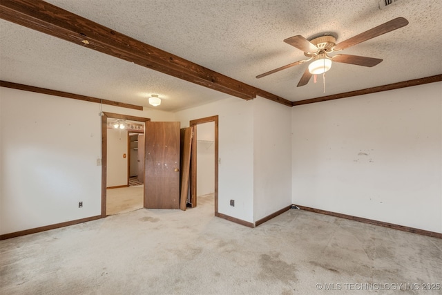 carpeted empty room featuring beam ceiling, ceiling fan, and a textured ceiling