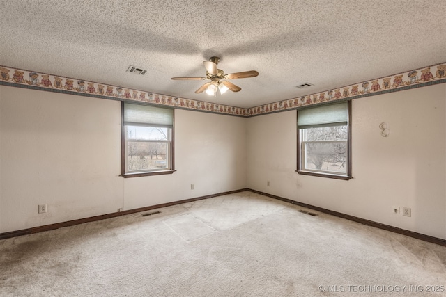 empty room featuring ceiling fan, carpet floors, and a textured ceiling