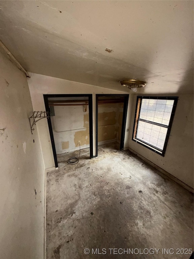 unfurnished bedroom featuring multiple closets