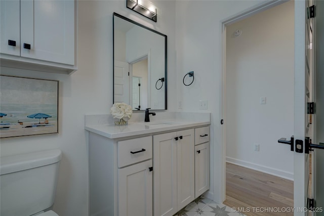 bathroom featuring vanity, toilet, and hardwood / wood-style floors