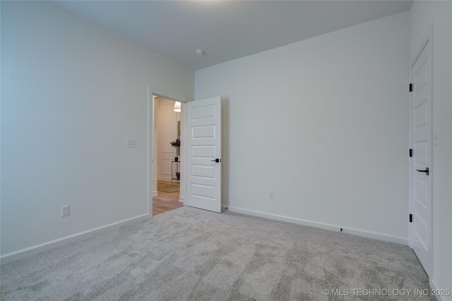 spare room featuring light carpet