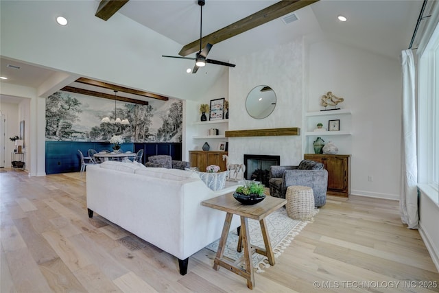 living room with beam ceiling, high vaulted ceiling, a fireplace, light hardwood / wood-style floors, and built in shelves