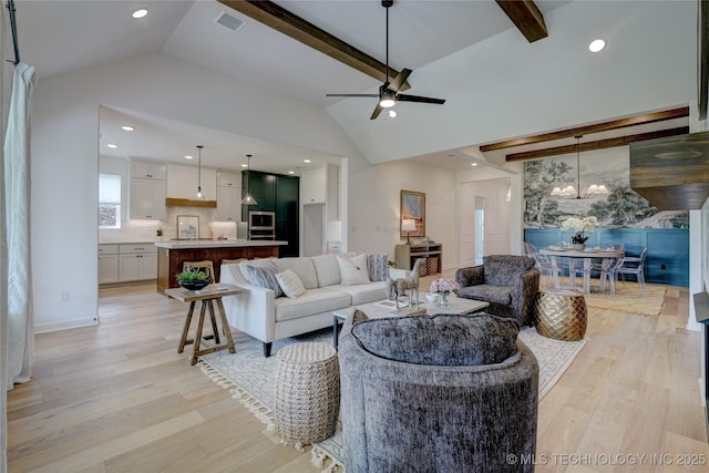 living room with beam ceiling, high vaulted ceiling, ceiling fan with notable chandelier, and light hardwood / wood-style floors