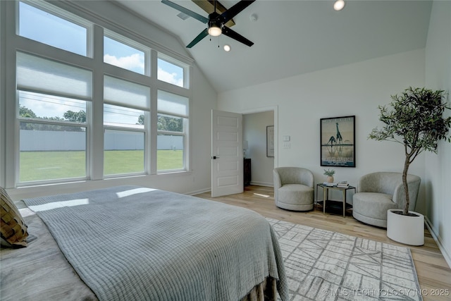 bedroom with high vaulted ceiling, ceiling fan, and light hardwood / wood-style flooring