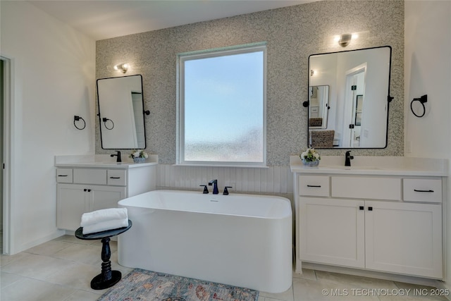 bathroom with tile patterned floors, vanity, and a tub