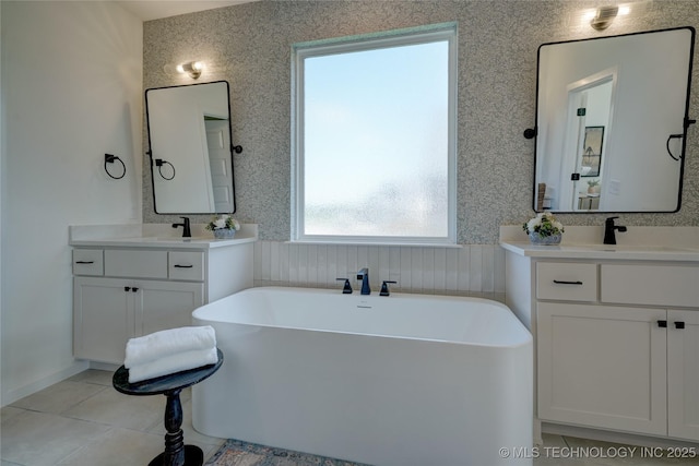 bathroom featuring tile patterned flooring, vanity, and a washtub