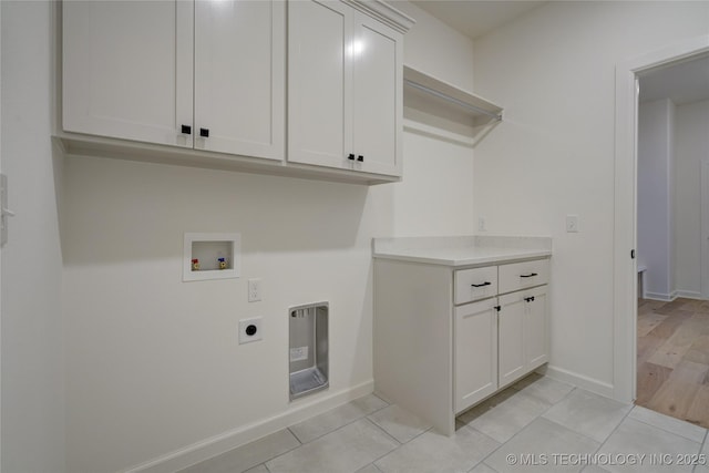 laundry area featuring cabinets, hookup for a washing machine, hookup for an electric dryer, and light tile patterned floors