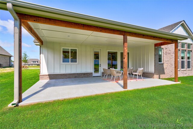 rear view of house with a patio and a lawn