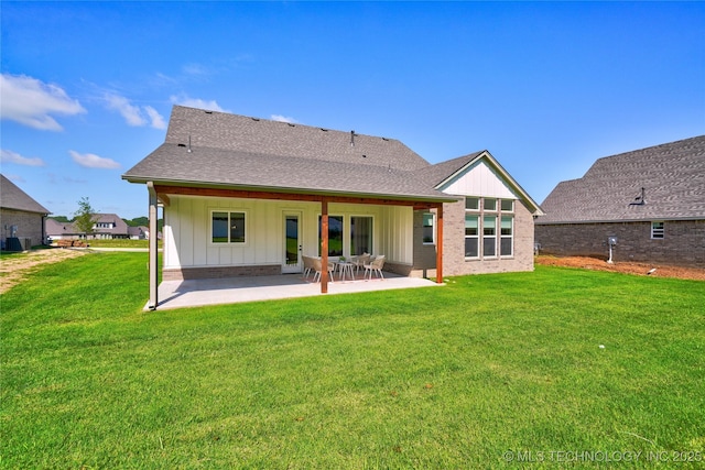 rear view of property featuring a yard and a patio area