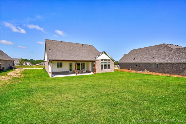 rear view of property with a yard and a patio