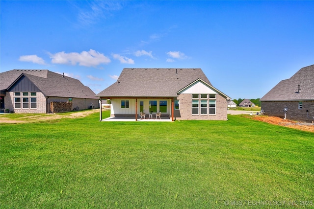 back of house with a patio area and a lawn