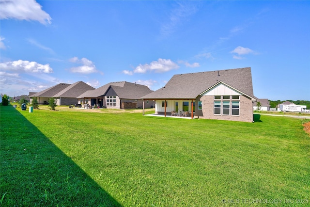 rear view of property featuring a patio and a lawn