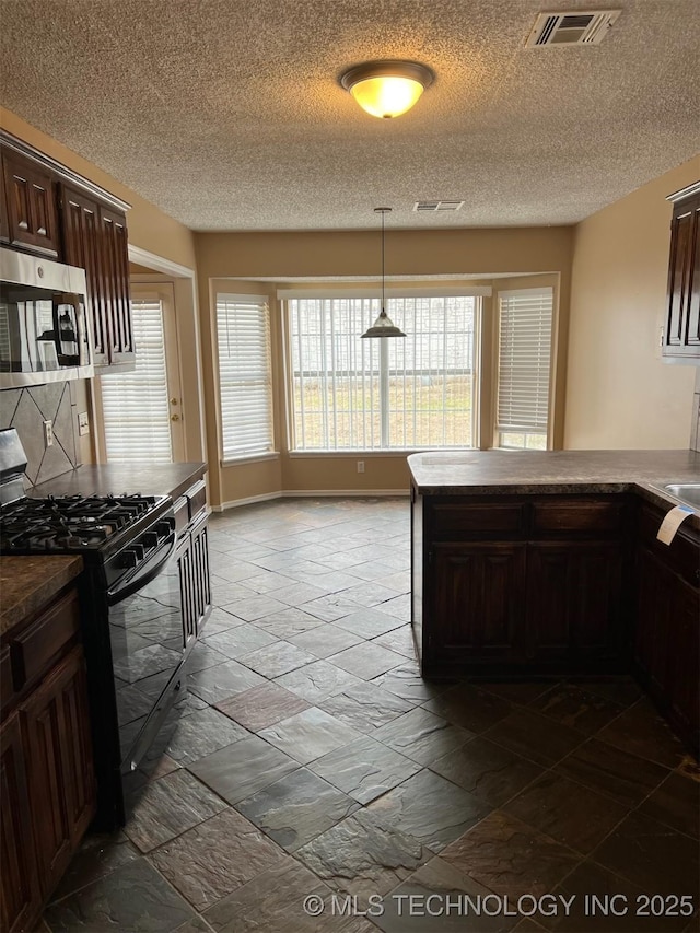 kitchen with black range with gas cooktop, hanging light fixtures, dark brown cabinets, and a textured ceiling