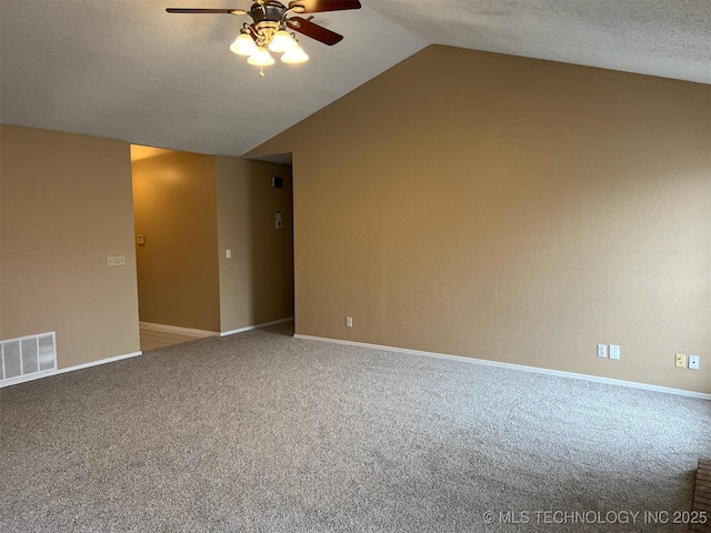 unfurnished room featuring lofted ceiling, a textured ceiling, carpet floors, and ceiling fan