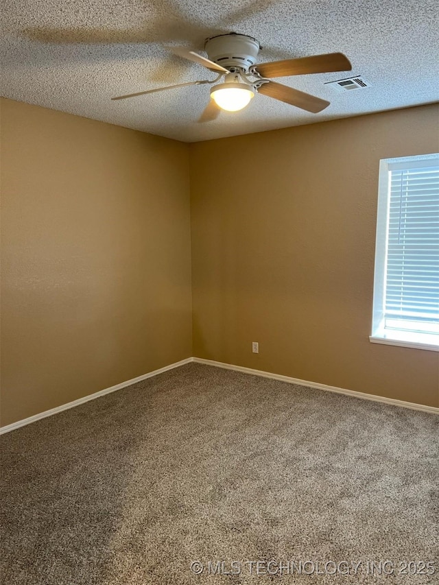 carpeted spare room featuring ceiling fan and a textured ceiling