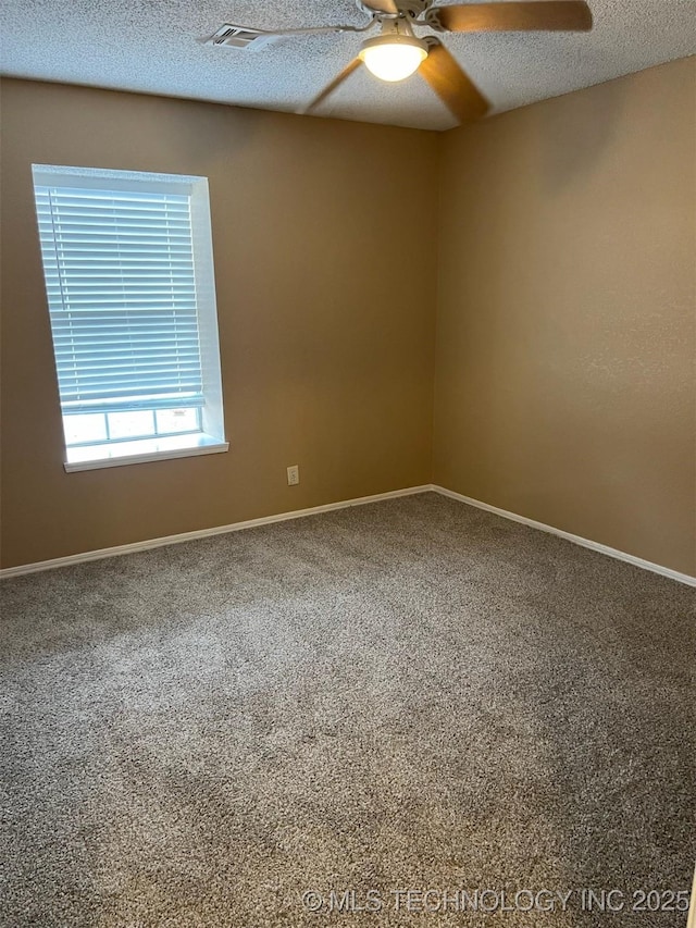 carpeted empty room featuring ceiling fan and a textured ceiling