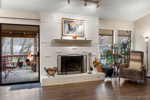 sitting room with hardwood / wood-style floors, a fireplace, and a textured ceiling