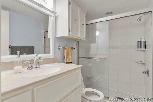 bathroom featuring walk in shower, vanity, and toilet