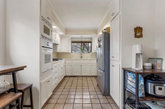 kitchen featuring white cabinetry, sink, crown molding, and appliances with stainless steel finishes