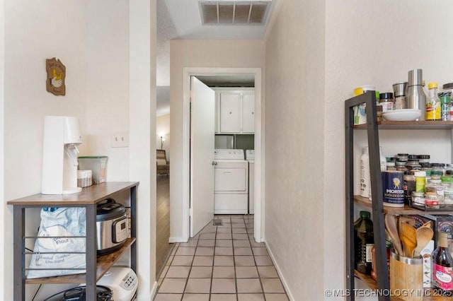 corridor featuring light tile patterned floors and washer and clothes dryer