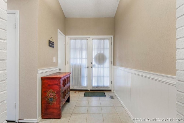 tiled entrance foyer featuring french doors