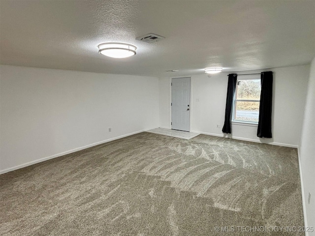 empty room with carpet flooring and a textured ceiling