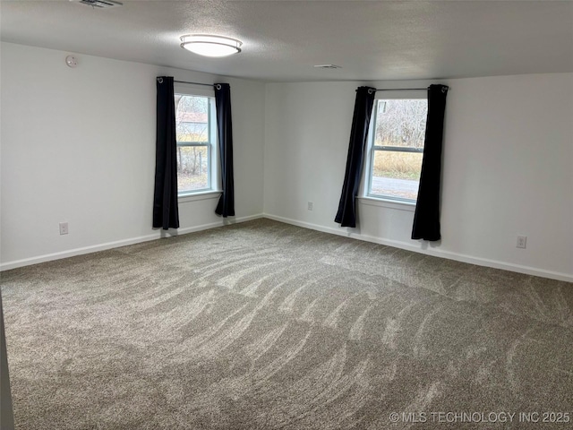 unfurnished room with a textured ceiling and carpet