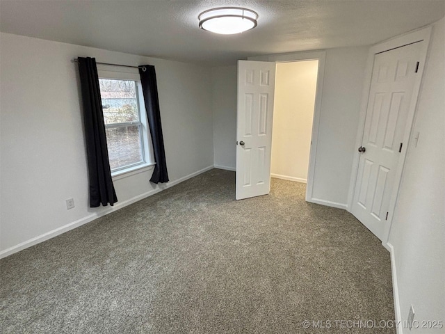 unfurnished bedroom with a textured ceiling and carpet