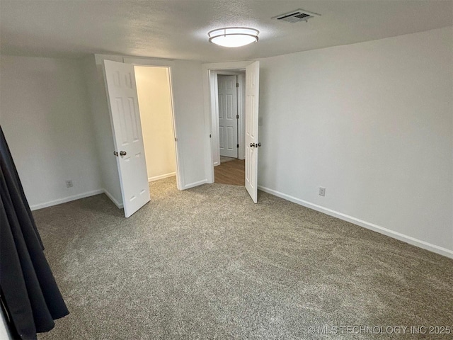 unfurnished bedroom with carpet and a textured ceiling