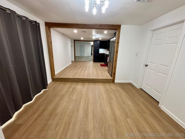 corridor featuring hardwood / wood-style flooring and a textured ceiling