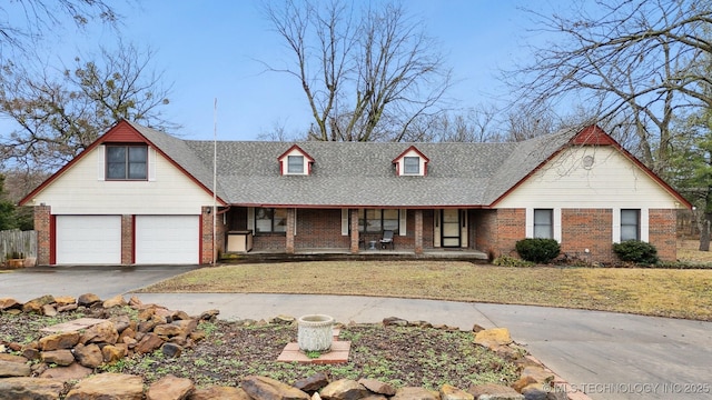 view of front of property with a garage, a porch, and a front yard