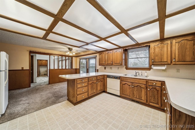 kitchen featuring sink, white appliances, light carpet, kitchen peninsula, and ceiling fan