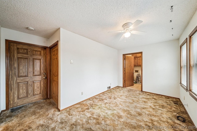 spare room with carpet flooring, a textured ceiling, and ceiling fan