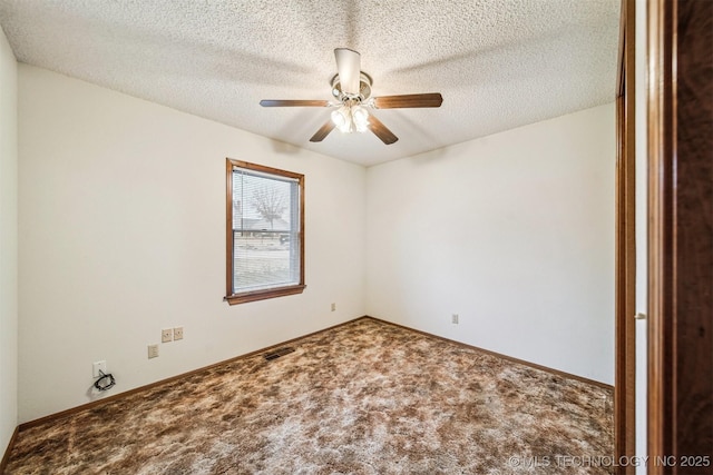 carpeted spare room featuring ceiling fan and a textured ceiling