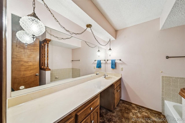 bathroom with vanity, a tub, and a textured ceiling